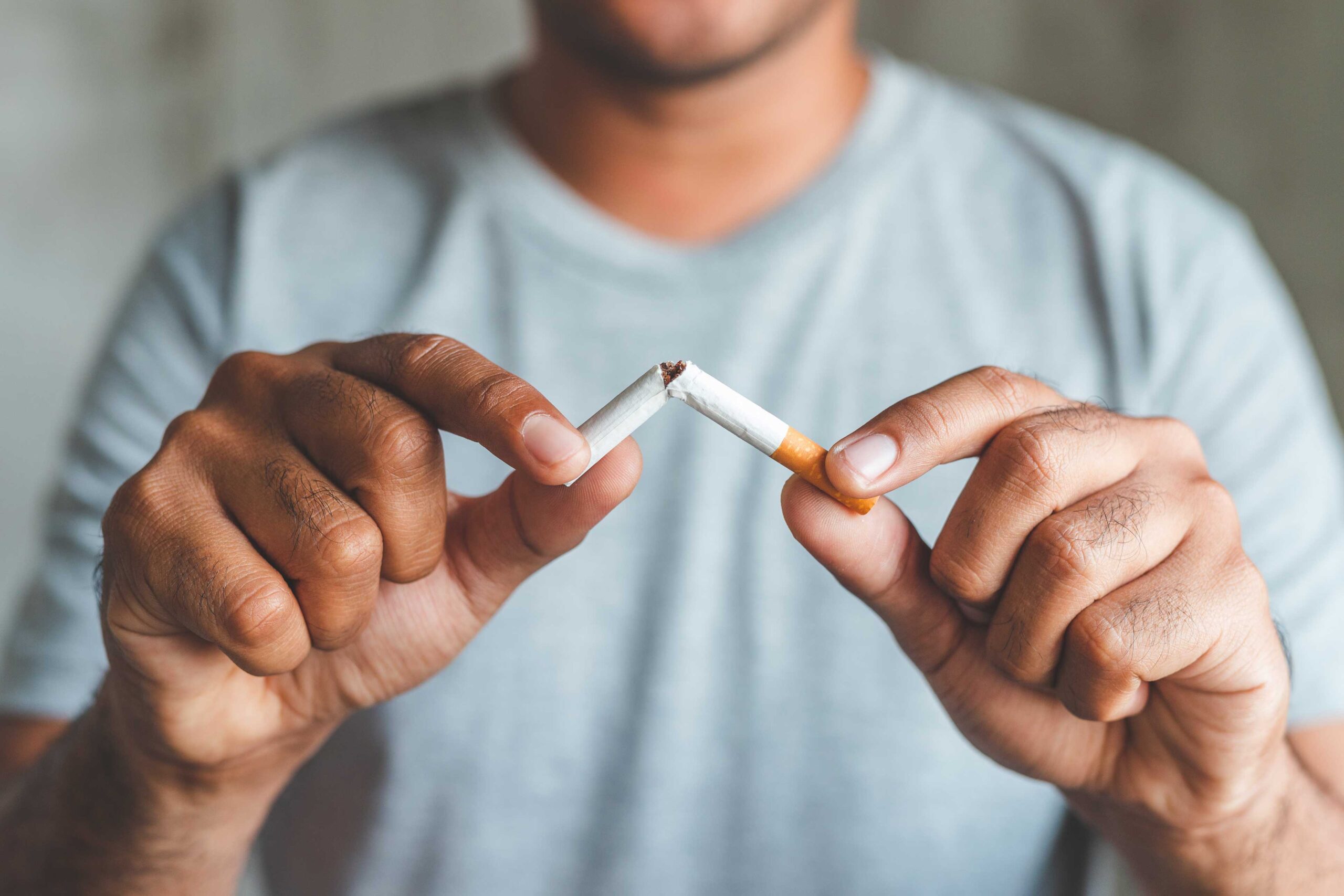 A smoking cessation ad with text that reads "Quit Smoking" and an image of a person's hand holding a cigarette. This image is used to encourage people to quit smoking.