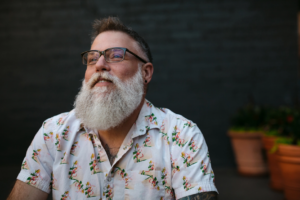 A man stares off into the distance with a look of satisfied reflection on his face.