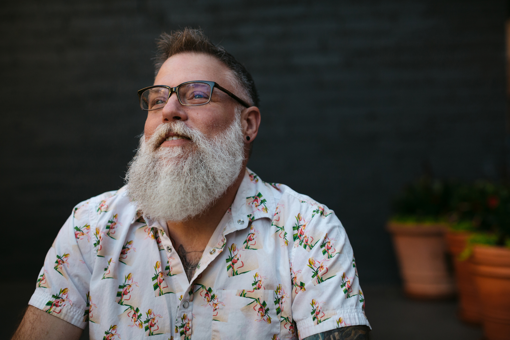 person smiling outdoors in a relaxed setting, reflecting confidence, comfort, and inclusive care.