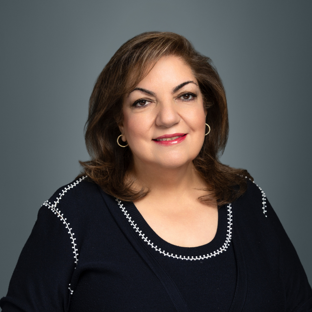 Professional headshot of a new Spectrum Medical provider smiling against a gray background, representing welcoming and compassionate patient care.