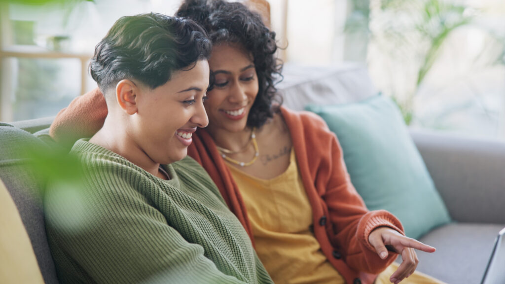 two people smiling together while accessing care resources from Spectrum Medical in a comfortable home setting.